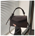 Detail of dark brown plaid handbag showing knot handle and textured crossbody strap - Brown