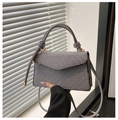 Detail of elegant patterned crossbody bag featuring knot handle and gold hardware detail - Gray