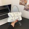 White pleated PU handbag with rhinestone handles and silver chain strap shown in lifestyle setting - White