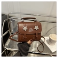 Detalle de bolso bandolera de cuero PU marrón con hebillas de estrellas y estampado moda - café