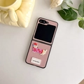 Close-up of pink leather phone case with dachshund embroidery and white goodluck tag - Leather Embroidery Dog-Pink / Samsung Z Flip 3