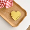 Détail macro du support de téléphone en cuir jaune en forme de cœur avec gravure chic - Jaune