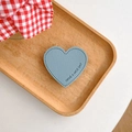 Detail of light blue heart leather phone grip with lychee texture and stitched edges - Blue
