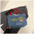 Detail der Chill Vibes Bestickung und des roten Webgurts an der Denim-Tragetasche - Hellblau
