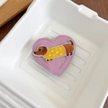Detail of a purple leather heart-shaped phone grip featuring dachshund embroidery and stitching - Purple