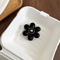 Makroaufnahme einer schwarzen Blumen-Handyhalterung mit goldenem Herz auf weißem Grund - Schwarz / Magnetic
