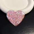 Vista macro di un supporto per telefono a cuore con glitter rosa e paillettes in resina - Cuore Rosa