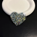 Macro shot of heart-shaped glitter phone stand with colorful sequins on ceramic tray - Black Heart