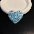 Macro detail of heart-shaped phone grip with sparkling blue and silver glitter flakes - Blue Heart
