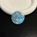 Detailed view of round phone grip with blue and silver glitter sequins on ceramic plate - Blue Round