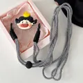 Detailansicht der schwarz-weiß geflochtenen Handykette mit süßem Cartoon-Anhänger - Schwarzhaariges Mädchen mit blauen Tränen und gelber Ente (Nr. 6) / Handy-Clip + Schwarz-weißes Schachbrettseil