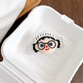 Detail eines süßen Cartoon-Mädchen-Handyclips mit weißer Strickmütze in einer weißen Box - Junge mit weißem Hut und schwarzer Brille (Nr. 1) / Transparenter Handy-Grip/Clip
