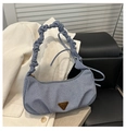 Detailed shot of light blue denim shoulder bag with gathered handle and metal plate - Blue