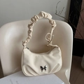Bolso de hombro crema con hebilla de mariposa y correa plisada en silla blanca - Blanco Roto