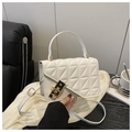 Detail of white quilted crossbody bag with black-gold lock and chain on dark wood table - White