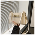 Detail of white crocodile embossed PU leather bag with gold metal clasp on hand - White
