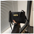 Close-up of black crocodile pattern leather bag with golden metal lock and thin strap - Black