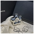 Detalle de un bolso plateado con forma de flor con perla blanca y cadena de estilo serpiente - Plateado