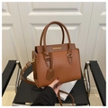 Close-up of brown litchi pattern leather bag with golden FASHION & BAGS text - Brown