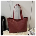 Detalle del bolso tote rojo oscuro con textura tejida, remaches plateados y correas - Rojo