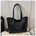 Detalle de bolso tote tejido negro con textura fina y elegantes remaches plateados en asa - Negro