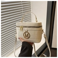 Detail einer weißen Box-Tasche mit goldenem M-Logo und glatter Lederstruktur - Weiß