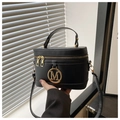 Detail der schwarzen Box-Tasche mit goldenem M-Logo und eleganter Ledertextur - Schwarz