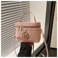 Detail der rosa Lederbox-Tasche mit goldenem M-Logo, Doppelreißverschluss und Tragegriff - Rosa