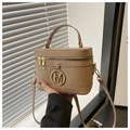 Close-up of khaki box bag featuring dual zippers and a metallic M logo on the front flap - Khaki