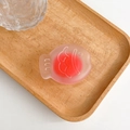Dettaglio di un supporto per cellulare a forma di pesce su un vassoio di legno - Rosso