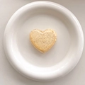 Macro shot of heart-shaped glitter phone grip with golden sequins in white ceramic tray - 3D Airbag Style - Yellow