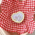 Nahaufnahme der herzförmigen Handyhalterung mit süßen Cartoon-Motiven auf Karomuster-Basis - Treibsand Griff-Gingham Herz Cartoon-Rosa Gelb