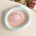 Détail d'un support de téléphone en forme de poisson sur un plateau en céramique ours pastel - Poisson rose