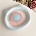 Close-up of frosted fish-shaped phone grip on a blue bear ceramic tray with floral decor - Blue Fish