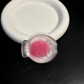 Detail of pink frosted taiyaki fish phone socket with embossed 000 texture on white plate - Rose Red Fish
