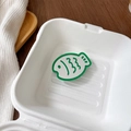 Detail of green fish-shaped retractable phone socket mirror inside a white box - Dark Green