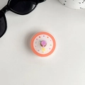 Macro shot of colorful rotating phone grip with heart and star patterns on gray surface - Transparent Stand - Rotating Mini Clock