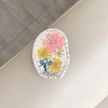 Detailaufnahme der ovalen Handyhalterung mit echten Trockenblumen und Silberfolie - Oval Echtblume-Silberfolie Rosa Rittersporn