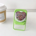 Detail of heart-shaped glitter MagSafe phone grip on a mini chair display with coffee cup - Colorful Small Dots
