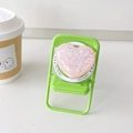 Close-up of glitter heart MagSafe phone grip on a miniature green folding chair - Pink Dots