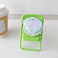 Macro view of purple glitter heart magnetic phone socket on a mini green chair - Blue Dots