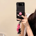 Black leather Galaxy Z Flip case with pink ball grip and clover pendant held by hand - Black Round Ball Ring Style (Includes Card Puppy Chain Pendant) / Samsung ZFlip3