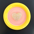 Macro detail of round phone socket featuring a sparkly glitter heart on pink and yellow base - Heart / Green