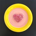 Macro detail of heart-shaped phone grip filled with pink and red sequins on a plate - Heart / Rose Red
