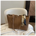 Bolso tote marrón grande con costuras blancas y pañuelo de seda sobre tela blanca - Tostado