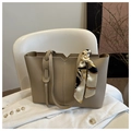 Detalle de bolso tote beige con textura suave y pañuelo de seda elegante en el asa - Caqui