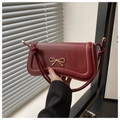 Dettaglio borsa in pelle opaca bordeaux con fiocco dorato e tracolle annodate a mano - Rosso