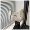 Detalle del bolso hobo de cuero blanco con lazo dorado y cadena dorada decorativa - Blanco