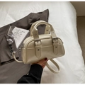 Detailaufnahme der cremeweißen Lackleder-Bowlingtasche mit Silberschnallen und Griff - Gebrochenes Weiß