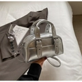 Detail der silbernen Bowlingtasche mit Leder-Schnallen und polierten Metallbeschlägen - Silber